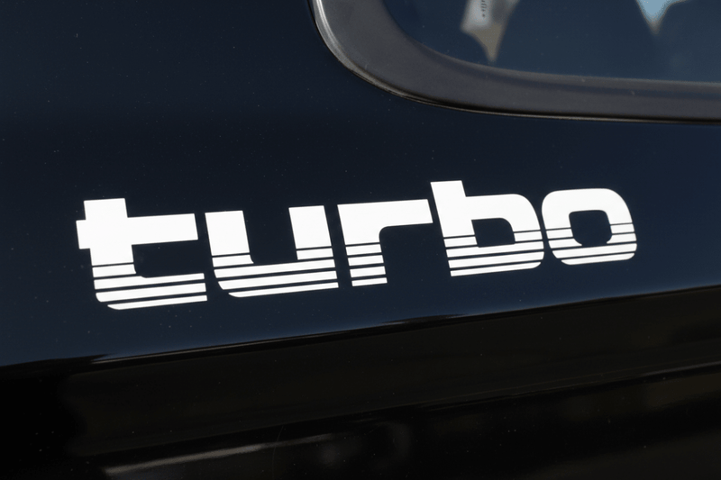White 100 Series Turbo sticker on black vehicle panel