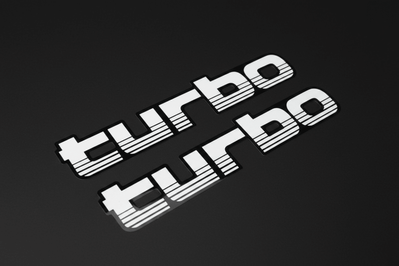 White 100 Series Turbo stickers angled overhead black background