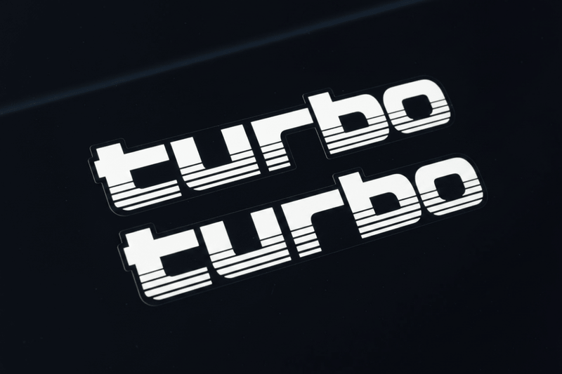 White 100 Series Turbo stickers macro close-up black background