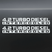 Load image into Gallery viewer, White 4.2 Turbo Diesel Intercooled stickers on dark background
