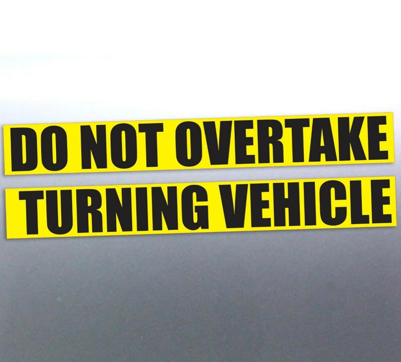 Do Not overtake turning vehicle decals on a silver car door